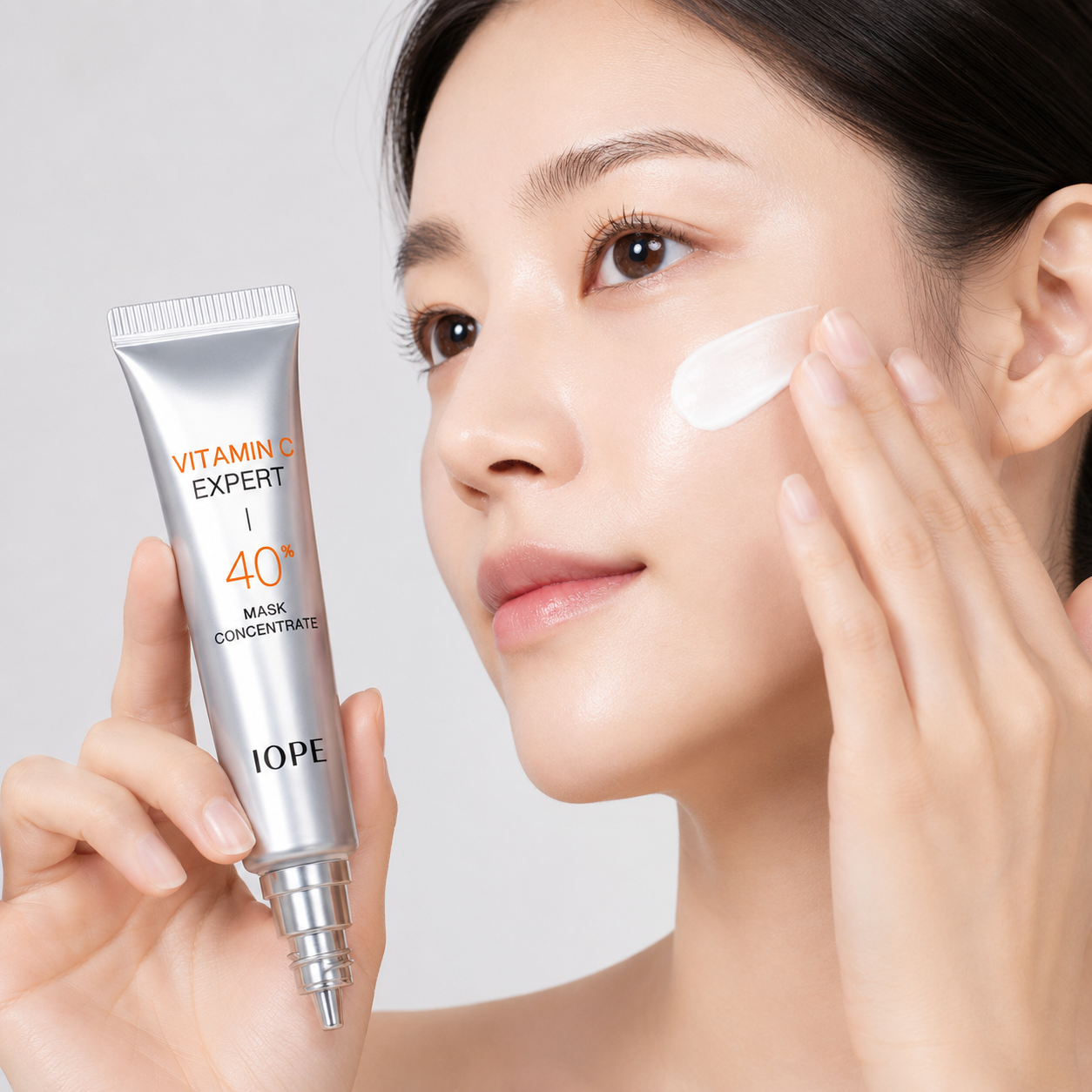 Woman applying IOPE Vitamin C Expert 40+ Mask Concentrate to her face.
